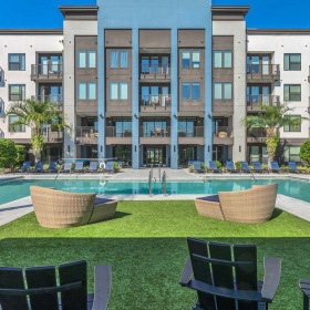Shimmering resort-style pool chairs on lawn near pool